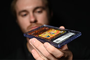 A CGC Quality Control Specialist examines a certified sports card for accuracy during the quality control step of the CGC grading process.